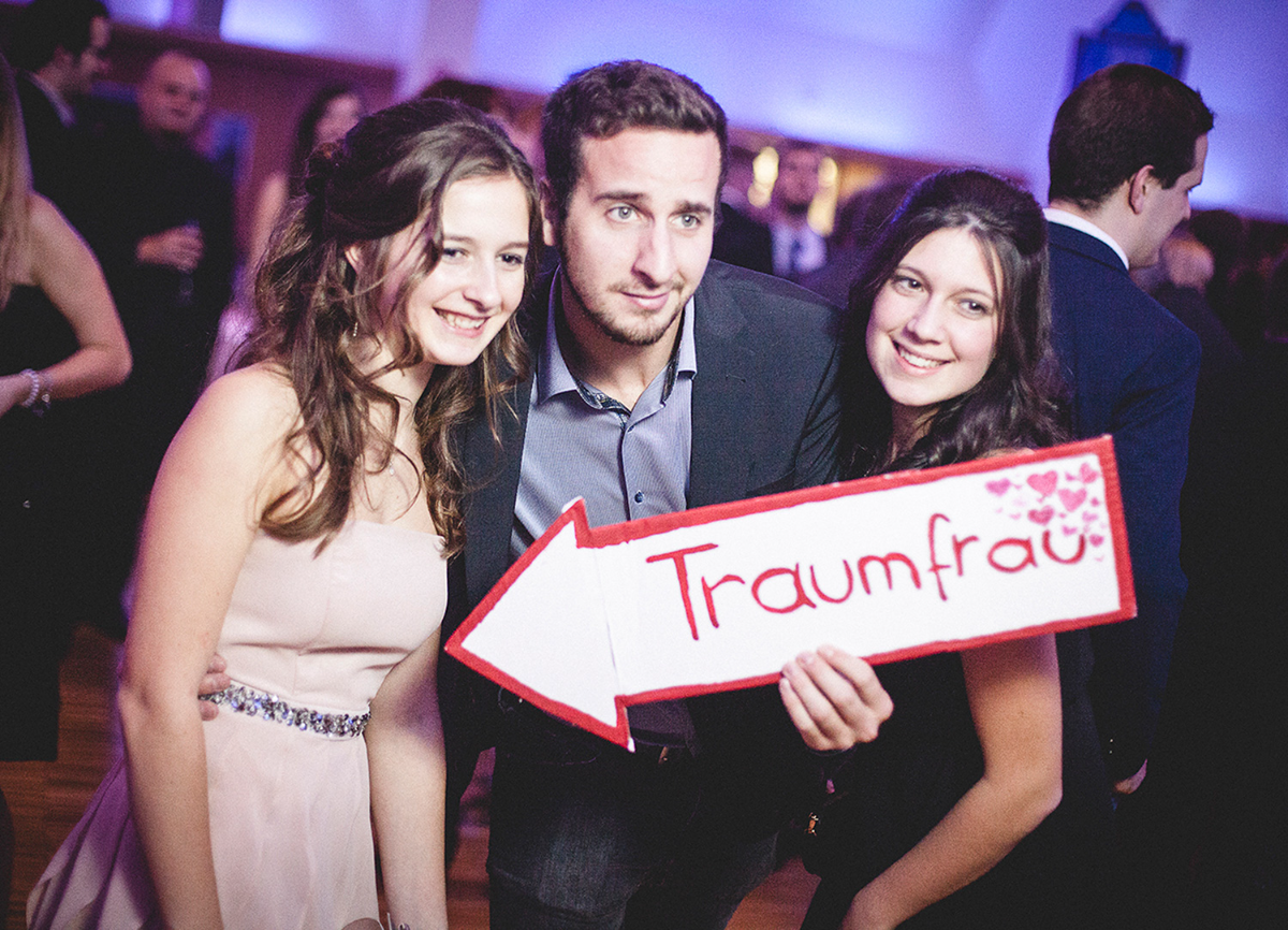 Freunde mit Schild ‚Traumfrau' vor der Fotobox